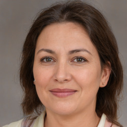 Joyful white adult female with medium  brown hair and brown eyes