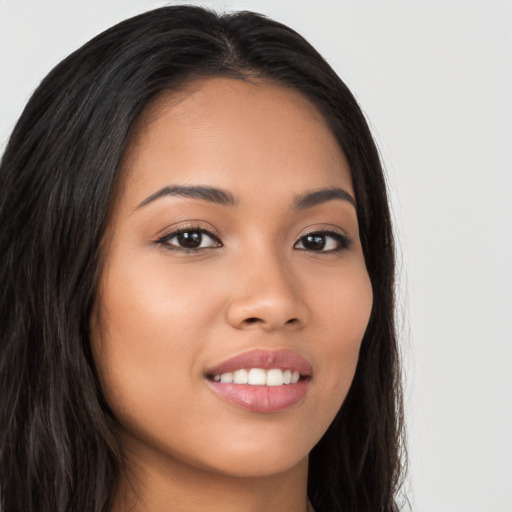 Joyful latino young-adult female with long  brown hair and brown eyes