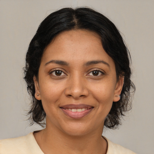 Joyful black young-adult female with medium  brown hair and brown eyes