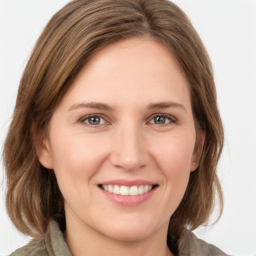 Joyful white young-adult female with medium  brown hair and green eyes