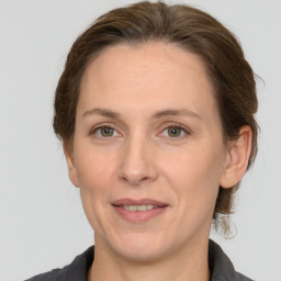 Joyful white adult female with medium  brown hair and grey eyes