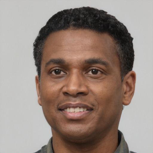 Joyful black young-adult male with short  black hair and brown eyes