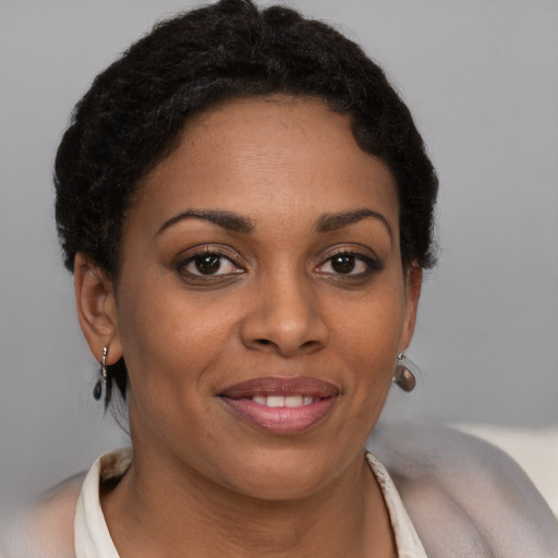 Joyful black young-adult female with short  brown hair and brown eyes