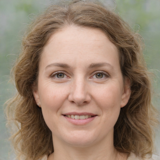 Joyful white young-adult female with medium  brown hair and green eyes