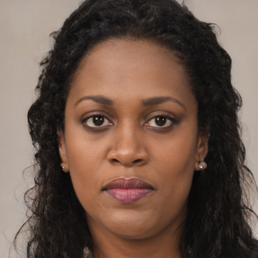 Joyful black young-adult female with long  brown hair and brown eyes
