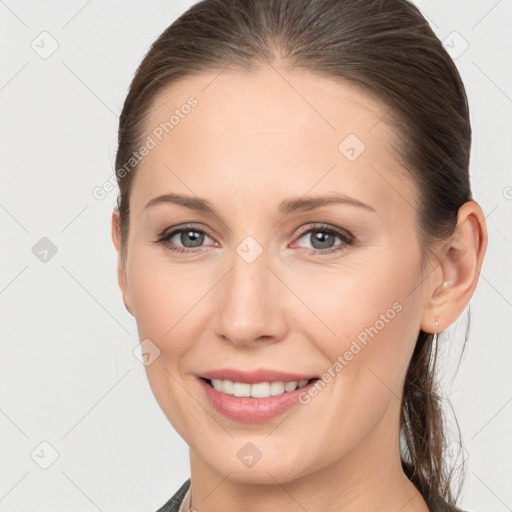 Joyful white young-adult female with medium  brown hair and grey eyes