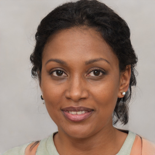 Joyful black adult female with medium  brown hair and brown eyes