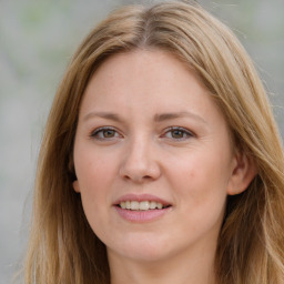 Joyful white young-adult female with long  brown hair and blue eyes