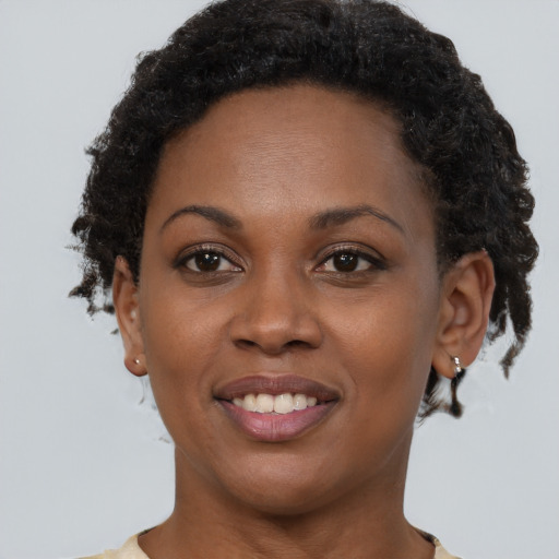 Joyful black young-adult female with short  brown hair and brown eyes