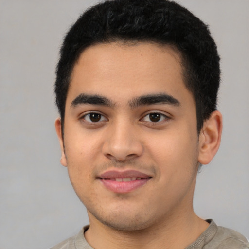 Joyful latino young-adult male with short  black hair and brown eyes