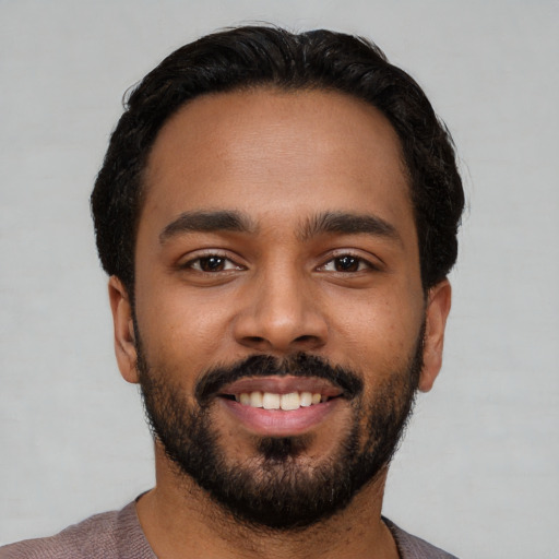 Joyful latino young-adult male with short  black hair and brown eyes