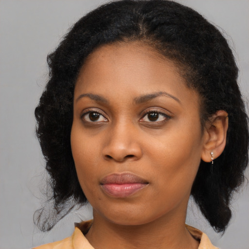 Joyful black young-adult female with medium  black hair and brown eyes
