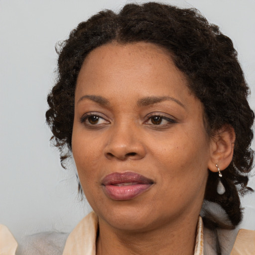 Joyful black adult female with medium  brown hair and brown eyes