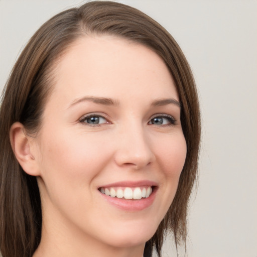 Joyful white young-adult female with long  brown hair and grey eyes