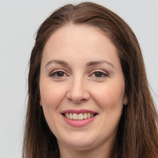 Joyful white adult female with long  brown hair and brown eyes