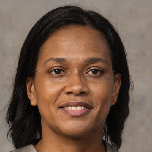 Joyful black adult female with medium  brown hair and brown eyes
