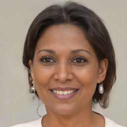 Joyful black adult female with medium  brown hair and brown eyes