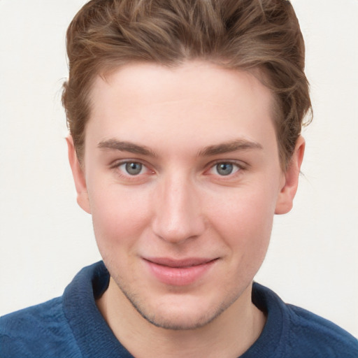 Joyful white young-adult male with short  brown hair and blue eyes