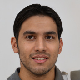 Joyful latino young-adult male with short  brown hair and brown eyes