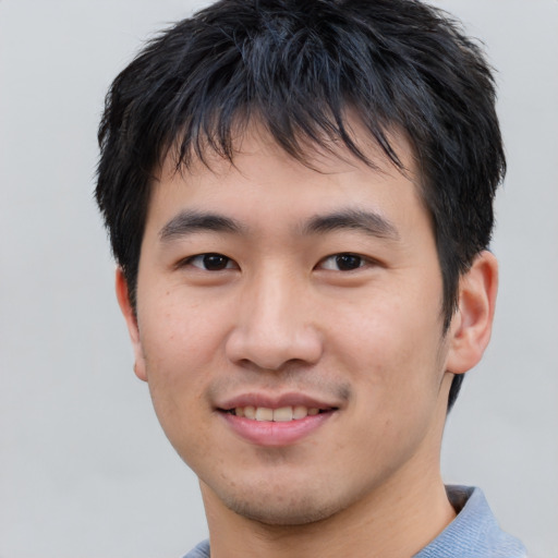 Joyful asian young-adult male with short  black hair and brown eyes