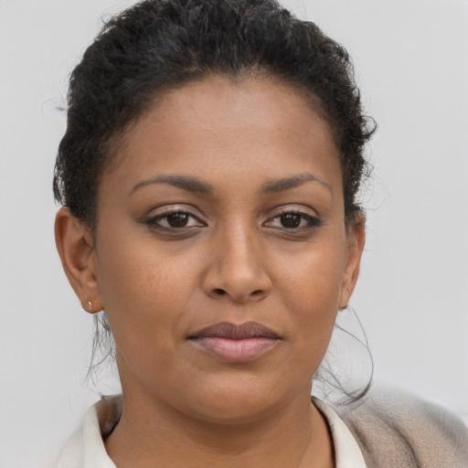 Joyful black young-adult female with short  brown hair and brown eyes