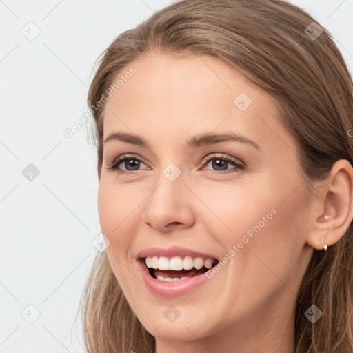 Joyful white young-adult female with long  brown hair and brown eyes