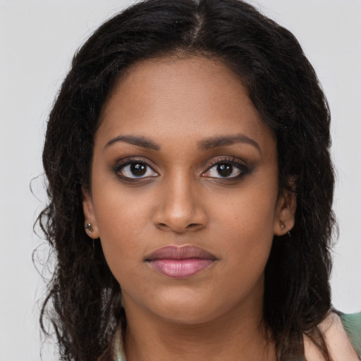 Joyful black young-adult female with long  brown hair and brown eyes
