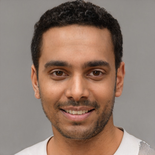 Joyful latino young-adult male with short  black hair and brown eyes
