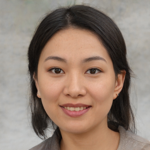 Joyful asian young-adult female with medium  brown hair and brown eyes