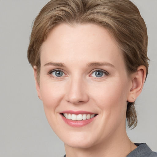 Joyful white young-adult female with medium  brown hair and blue eyes