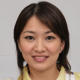 Joyful asian young-adult female with medium  brown hair and brown eyes