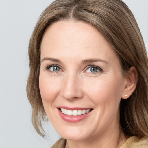 Joyful white adult female with medium  brown hair and blue eyes