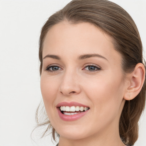 Joyful white young-adult female with long  brown hair and blue eyes