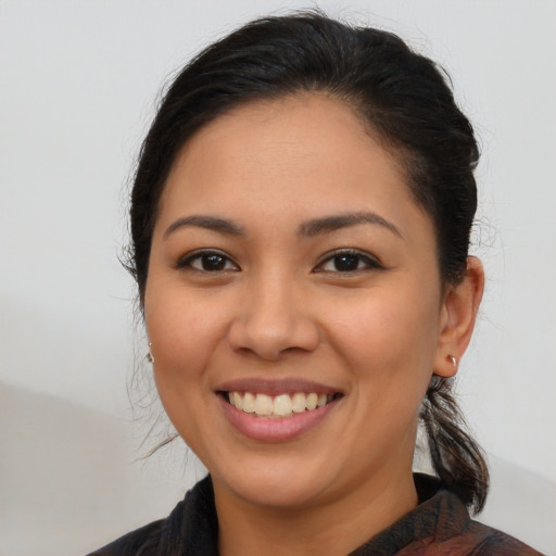 Joyful latino young-adult female with long  brown hair and brown eyes