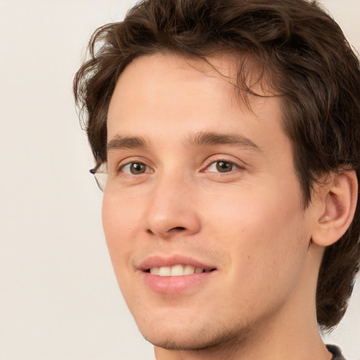 Joyful white young-adult male with short  brown hair and green eyes