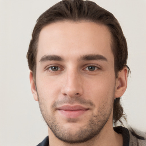 Joyful white young-adult male with short  brown hair and grey eyes