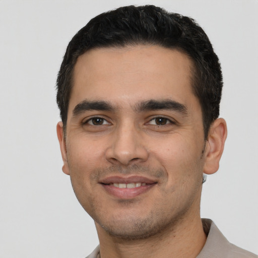 Joyful white young-adult male with short  black hair and brown eyes