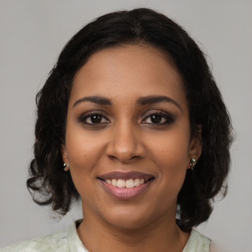 Joyful black young-adult female with medium  black hair and brown eyes