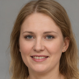 Joyful white young-adult female with long  brown hair and grey eyes