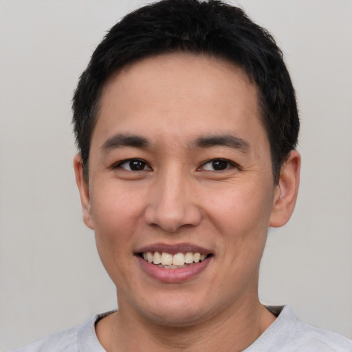 Joyful asian young-adult male with short  brown hair and brown eyes