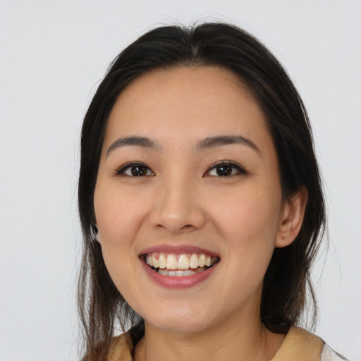 Joyful latino young-adult female with long  brown hair and brown eyes