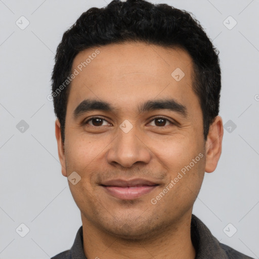 Joyful latino young-adult male with short  black hair and brown eyes