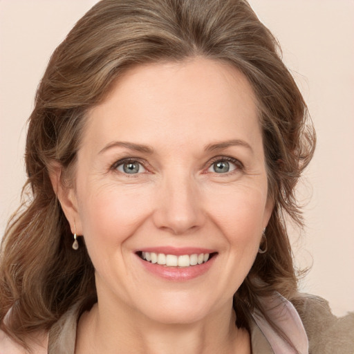 Joyful white adult female with medium  brown hair and grey eyes