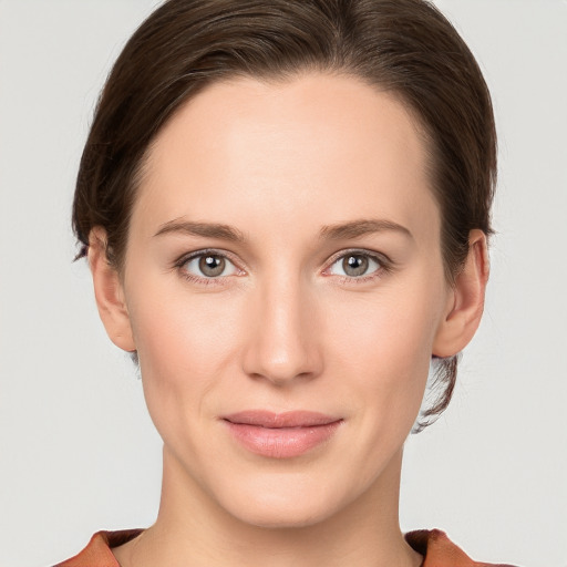 Joyful white young-adult female with medium  brown hair and grey eyes