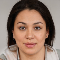 Joyful latino young-adult female with medium  brown hair and brown eyes
