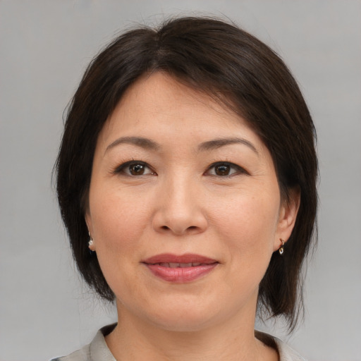 Joyful asian adult female with medium  brown hair and brown eyes
