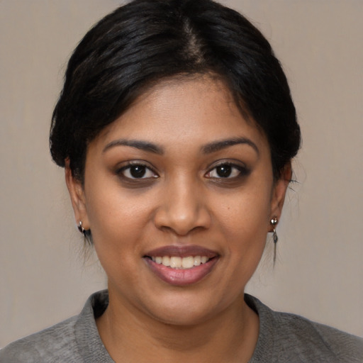 Joyful latino young-adult female with medium  black hair and brown eyes