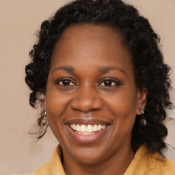 Joyful black adult female with long  brown hair and brown eyes