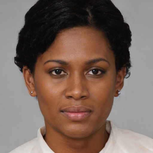 Joyful black young-adult female with short  black hair and brown eyes