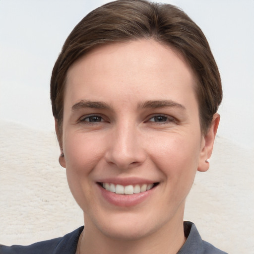 Joyful white young-adult female with short  brown hair and grey eyes